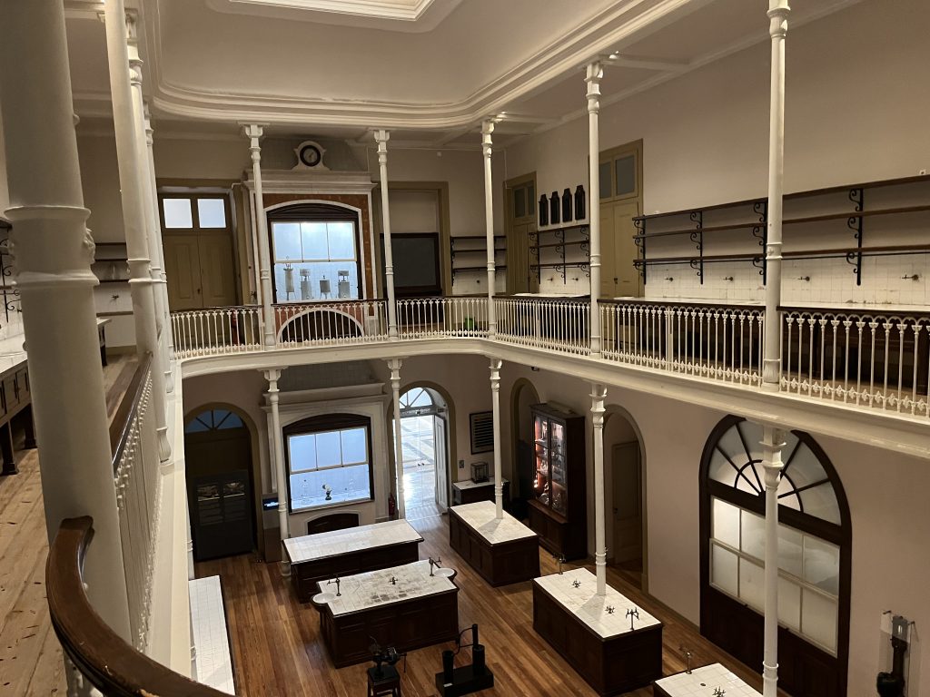 19th Century Teaching Laboratory at the National Museum of Natural History and Science, University of Lisbon. Large open space with a mezzanine walkway. On the main floor, tiled worktables with valves for chemical experiments and demonstrations.